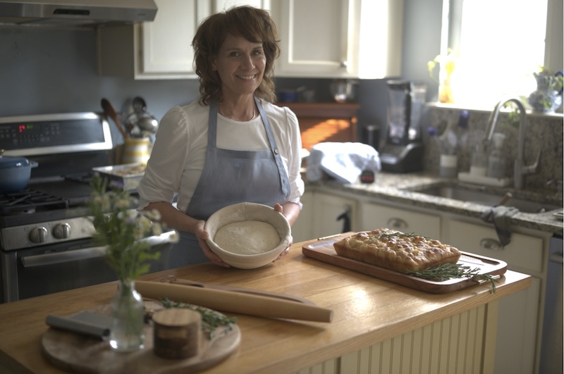 Lise in her kitchen holding a bowl of dough